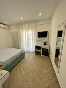 a bedroom with a bed and a desk with a mirror at Ametista Rooms Tropea in Tropea