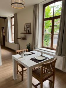 a dining room with a white table and two chairs at B&B Sjaanderhof in Maastricht