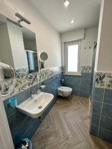 a bathroom with a sink and a toilet and a mirror at Ametista Rooms Tropea in Tropea