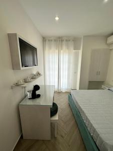 a hotel room with a bed and a desk and a television at Ametista Rooms Tropea in Tropea +52 photos