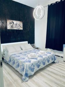 a bedroom with a bed with a blue and white blanket at Camera in centro storico in Olbia