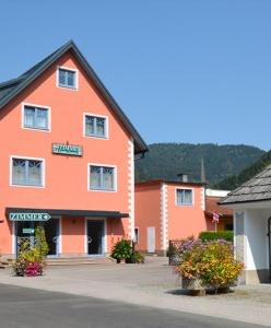 un edificio arancione con dei fiori di fronte di Privatzimmervermietung Fiausch a Kalwang
