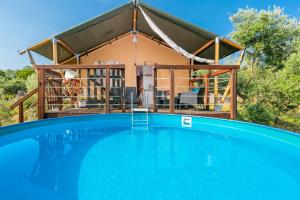 a house with a swimming pool in front of it at Prima insula glamping in Brusići
