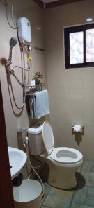 uma casa de banho com um WC e um chuveiro em MilVir Tourist INN em El Nido
