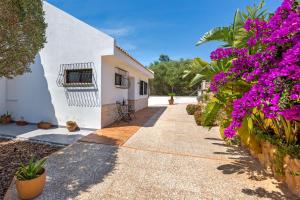 un chemin menant à une maison avec des fleurs violettes dans l'établissement Ferienhaus Casa Kristel, à Badia Gran