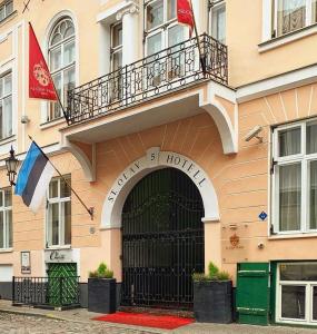 a hotel building with a gate and two flags at St.Olav Hotel in Tallinn