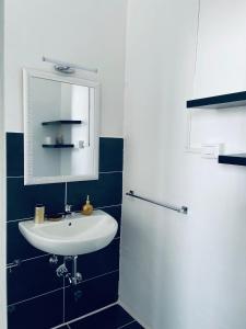 a bathroom with a white sink and a mirror at Camera in centro storico in Olbia