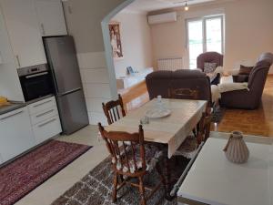 een keuken en een woonkamer met een tafel en stoelen bij Apartman Dakovic in Zlatište