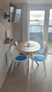 a table and chairs in a room with a window at Campingland Ostsee - Mobilheim 74Strandzauber NEU! in Schashagen