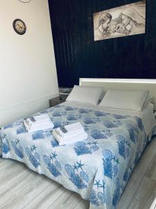 a bedroom with a bed with a blue and white comforter at Camera in centro storico in Olbia