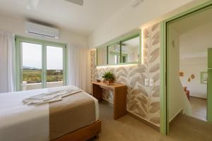 a bedroom with a bed and a large window at Plioni Villas & Suites in Mikri Vigla