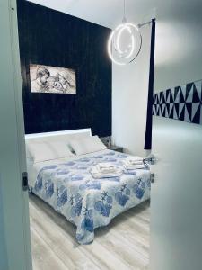 a bedroom with a bed with a blue and white blanket at Camera in centro storico in Olbia