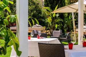 a white table with chairs and an umbrella at Hotel Isola Sacra Rome Airport in Fiumicino