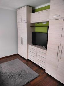 a living room with a tv and wooden cabinets at Apartament Baldachówka in Rzeszów