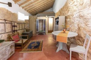 a room with a table and chairs and a stone wall at Pátio Serrano in Rio Maior