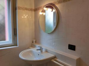 ein Bad mit einem Waschbecken und einem Spiegel in der Unterkunft Appartamento Gemelli in Cavalese