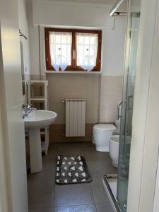 een badkamer met een wastafel, een toilet en een douche bij Alice’s Home in Bolano