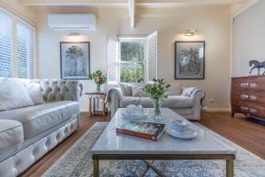 a living room with a couch and a table at Carramar Coach House, Romantic Falls Retreat in Wentworth Falls