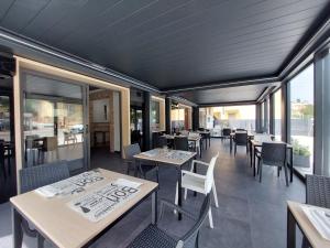 un ristorante con tavoli, sedie e finestre di Novo Motel a Tortoreto