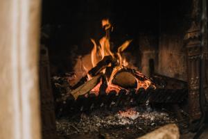 ein Feuer in einem Steinofen mit Flammen in der Unterkunft Carramar Coach House, Romantic Falls Retreat in Wentworth Falls