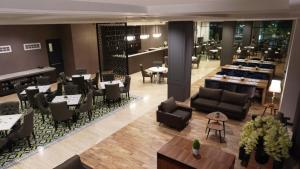 a restaurant with couches and tables and a bar at Rivoli Hotel Jakarta in Jakarta