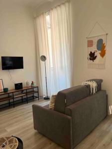salon z kanapą i telewizorem z płaskim ekranem w obiekcie Colosseo Living Suites w Rzymie