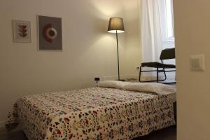 罗马Colosseo Living Suites的卧室里有一张床、一盏灯和一把椅子