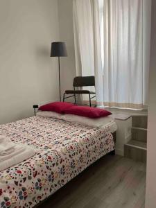 um quarto com uma cama, uma cadeira e uma janela em Colosseo Living Suites em Roma