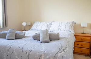 a bedroom with a white bed with pillows on it at Alan's House in Staffin