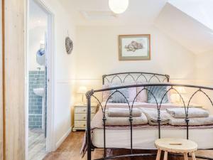 a bedroom with a metal bed in a room at The Hayloft in Tenby +31 photos