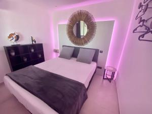 een slaapkamer met een bed met een spiegel en roze verlichting bij MarinesAppartement, Le quai Tropézien marina in Saint-Tropez