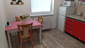 una pequeña cocina con mesa y sillas rosas en BYT POD ZÁMKEM, en Valtice