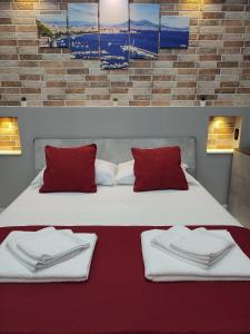 una camera con due letti con cuscini rossi e bianchi di B&B May Dream a Napoli