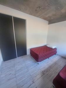 Un dormitorio con una cama roja en la esquina de una habitación en El quincheto, en Salta 2 fotos más