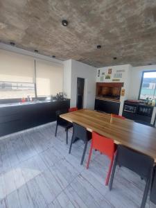 Una habitación grande con una mesa y sillas de madera. en El quincheto, en Salta