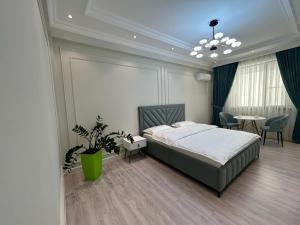 1 dormitorio con 1 cama, mesa y sillas en Home Apartment Complex, en Shymkent