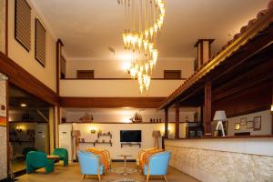 a living room with chairs and a table and a chandelier at Kuzey Park Hotel in Gokceada Town