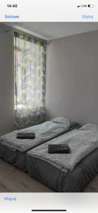 two twin beds in a room with a window at Mega widok 6 in Szklarska Poręba