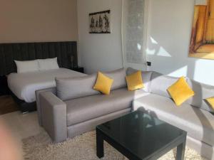 ein Wohnzimmer mit einem Sofa und einem Bett in der Unterkunft Pavillon avec piscine privée - AL MAADEN Marrakech in Marrakesch