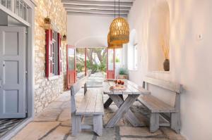a dining room with a wooden table and benches at Villa Gaia - Traditional Stone Villa in Rózia