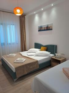 a bedroom with two beds and a chandelier at Casa Constantin Vic in Eforie Nord