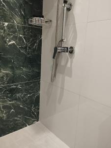 La salle de bains est pourvue d'une douche et d'un mur en marbre vert. dans l'établissement Manganas Studios, à Paleokastritsa