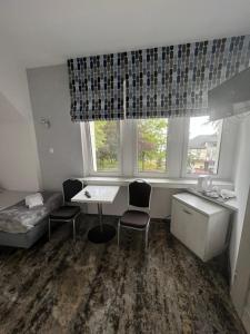 een kamer met een bureau, stoelen en een raam bij HORIZON in Ustka
