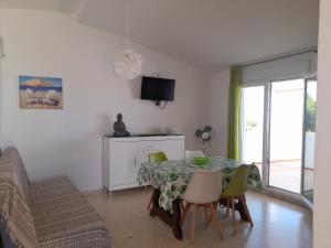 a dining room with a table with chairs and a television at Apartamentos Vista in Peniscola