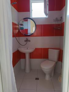 a red and white bathroom with a toilet and a mirror at Aparthotel Sofia in Gonio in Gonio