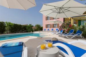 a swimming pool with a table with two glasses of orange juice at Apartments "Alen" in Nedeščina