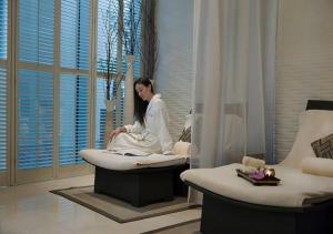 uma mulher sentada numa banheira num quarto em Fashion Avenue Dubai Mall no Dubai