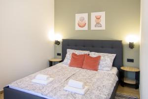 a bedroom with a bed with two orange pillows at Apartments & Rooms Darrer in Poreč