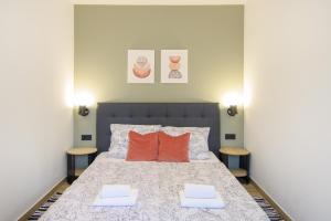 a bedroom with a bed with two orange pillows at Apartments & Rooms Darrer in Poreč