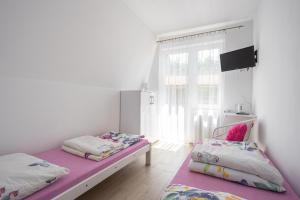 een slaapkamer met 2 bedden en een raam bij Pokoje u Kasi in Mielno